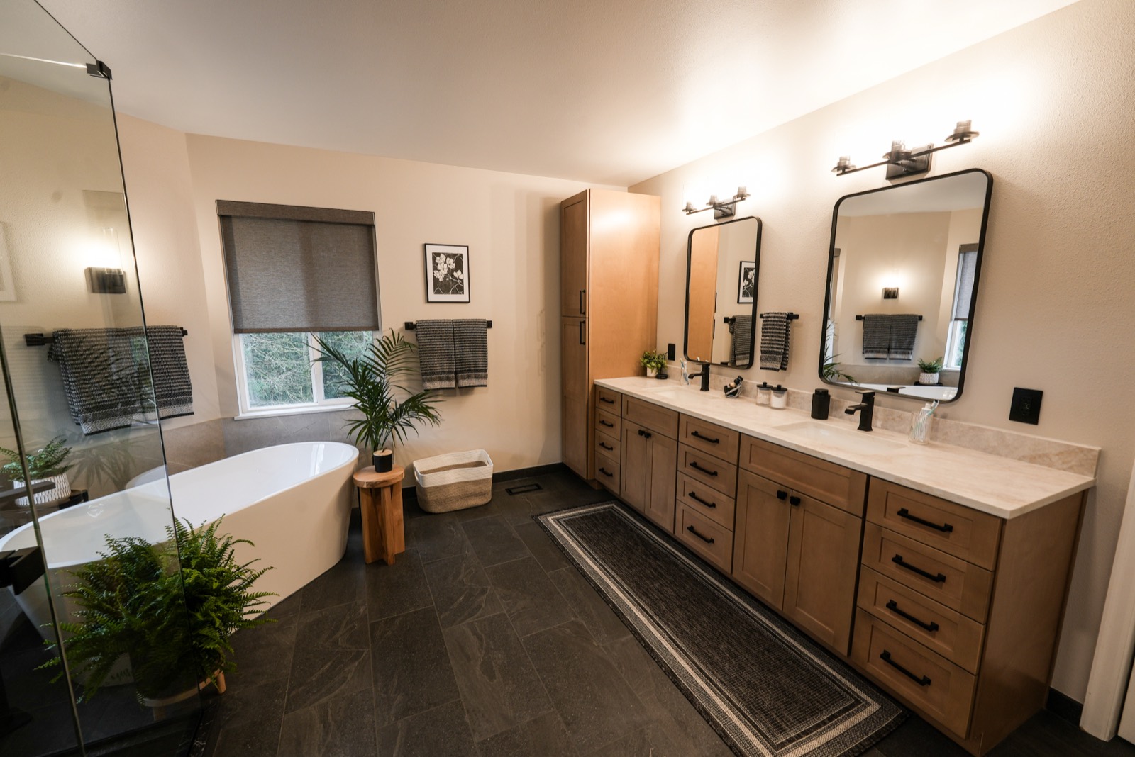 Bathroom remodel with a wood double vanity and black fixtures
