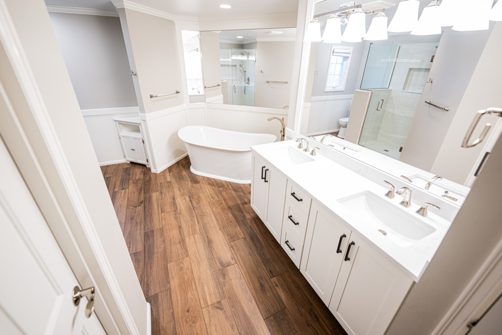 Bathroom remodel with a freestanding tub and white vanity