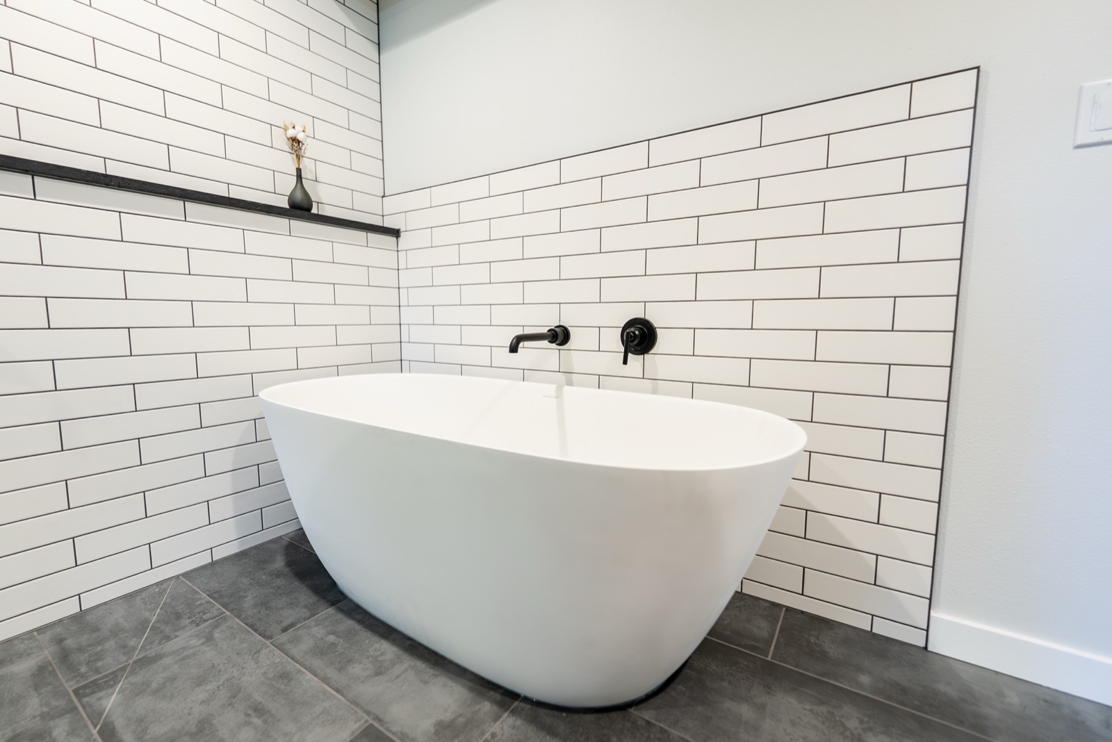 Bathroom remodel with white subway tile and a freestanding tub