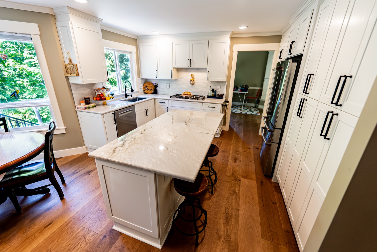 Bright kitchen remodel with a white marble waterfall island