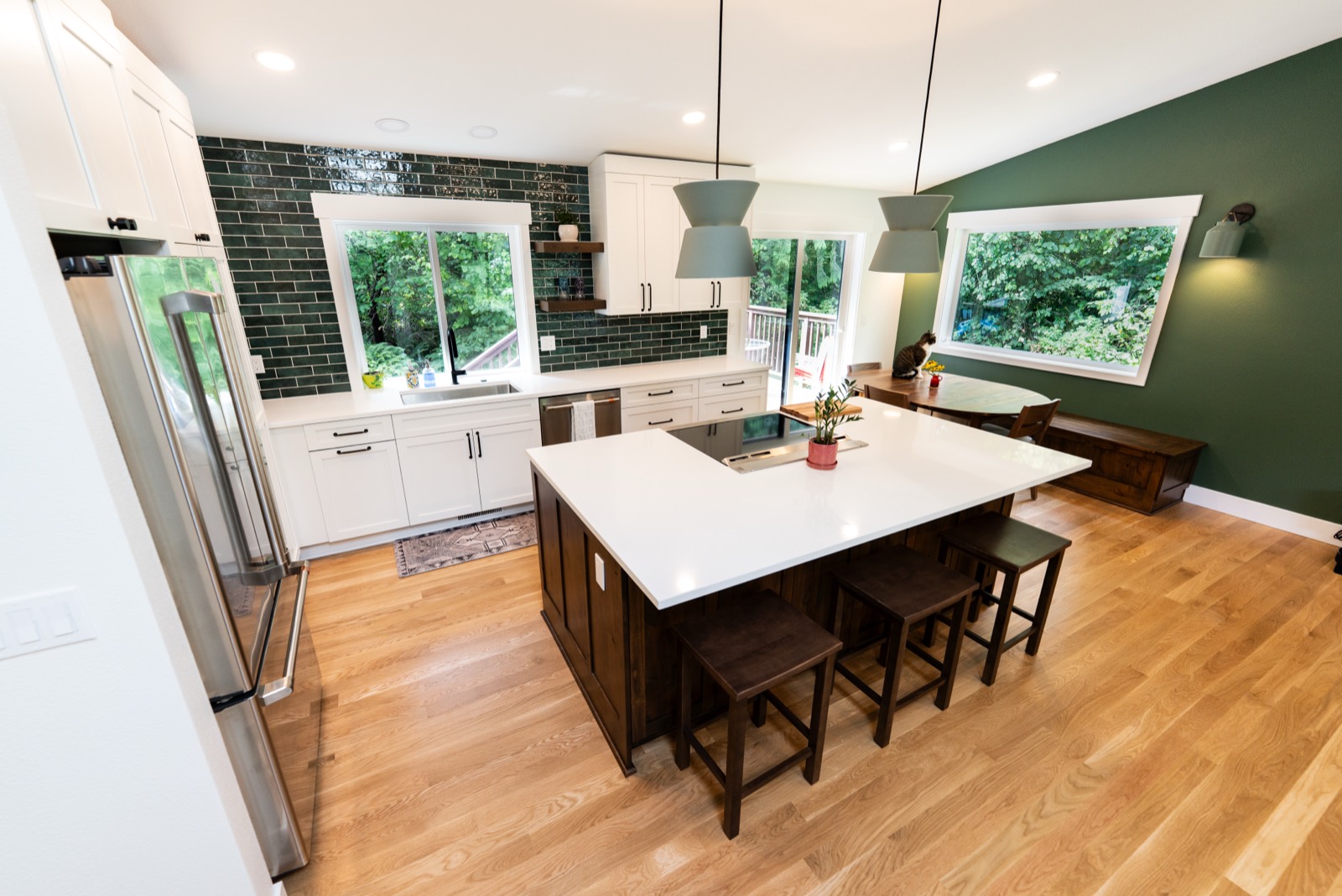 Kitchen remodel with green subway tile and a waterfall island